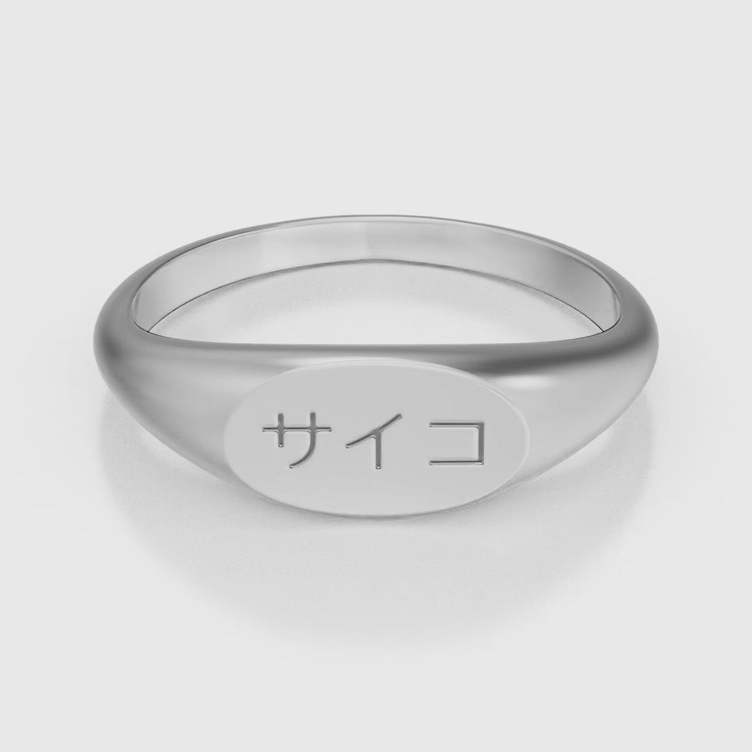 Silver stainless steel 316L signet ring with Japanese SAIKO logo engraved placed on the ground rotating 360 degrees with a white background