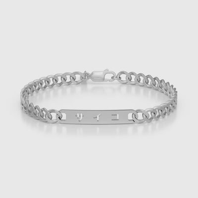 Silver stainless steel 316L cuban chain bracelet with Japanese SAIKO logo cut through the pendant placed on the ground rotating 360 degrees with a white background