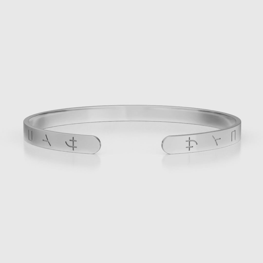 Silver stainless steel 316L cuff bracelet bangle with Japanese SAIKO logo engraved placed on the ground rotating 360 degrees with a white background