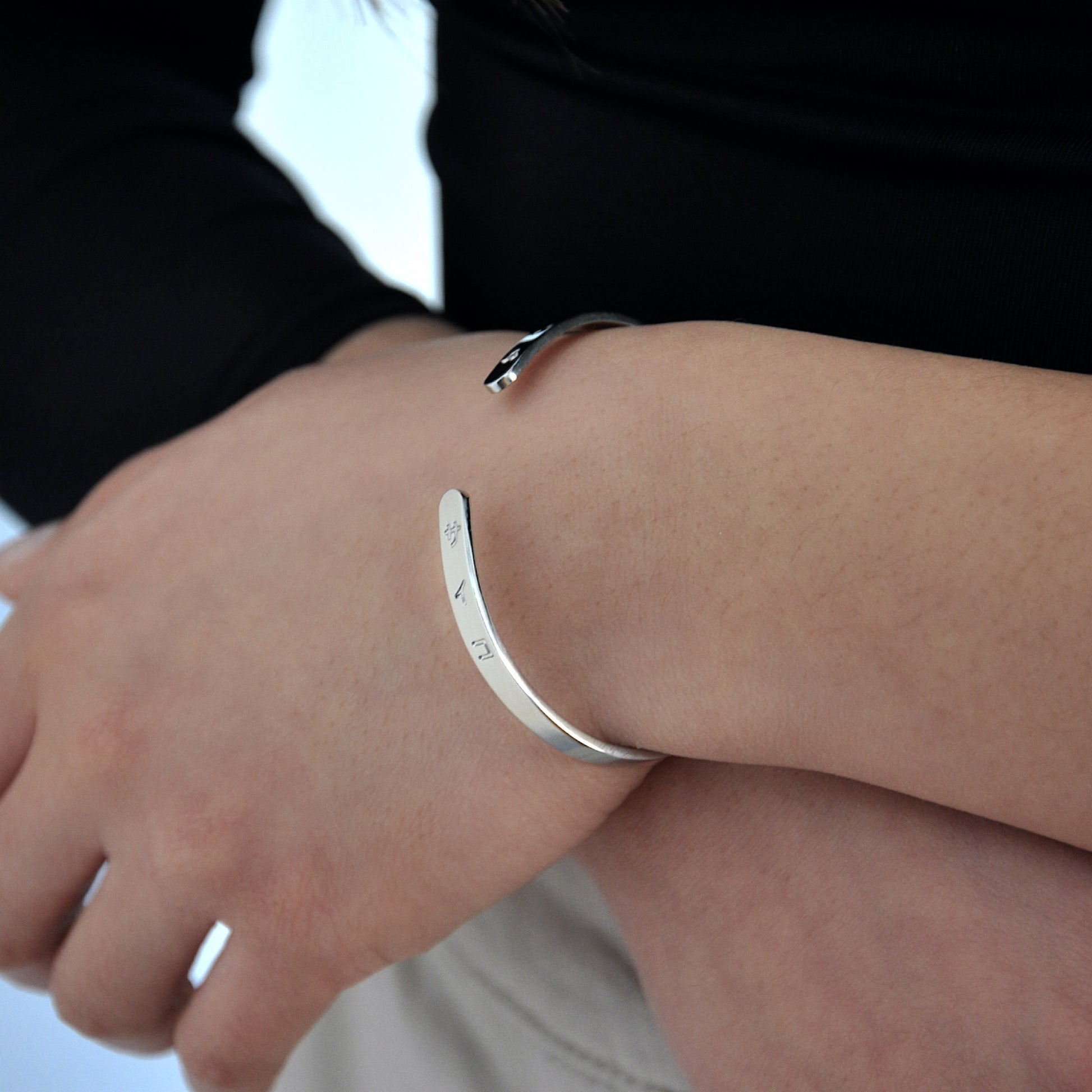 woman girl female wearing silver cuff bracelet made from 316L polished stainless steel with japanese character logo engraved onto the signet