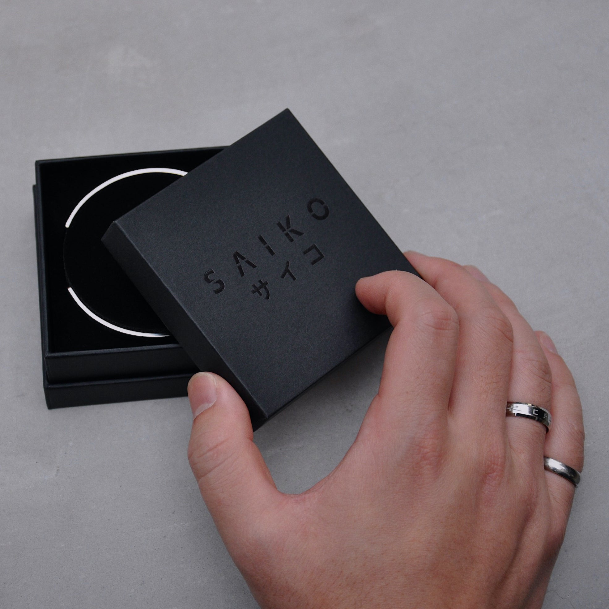 unboxing silver cuff bracelet made from 316L polished stainless steel with japanese character logo engraved onto the signet from black jewellery box