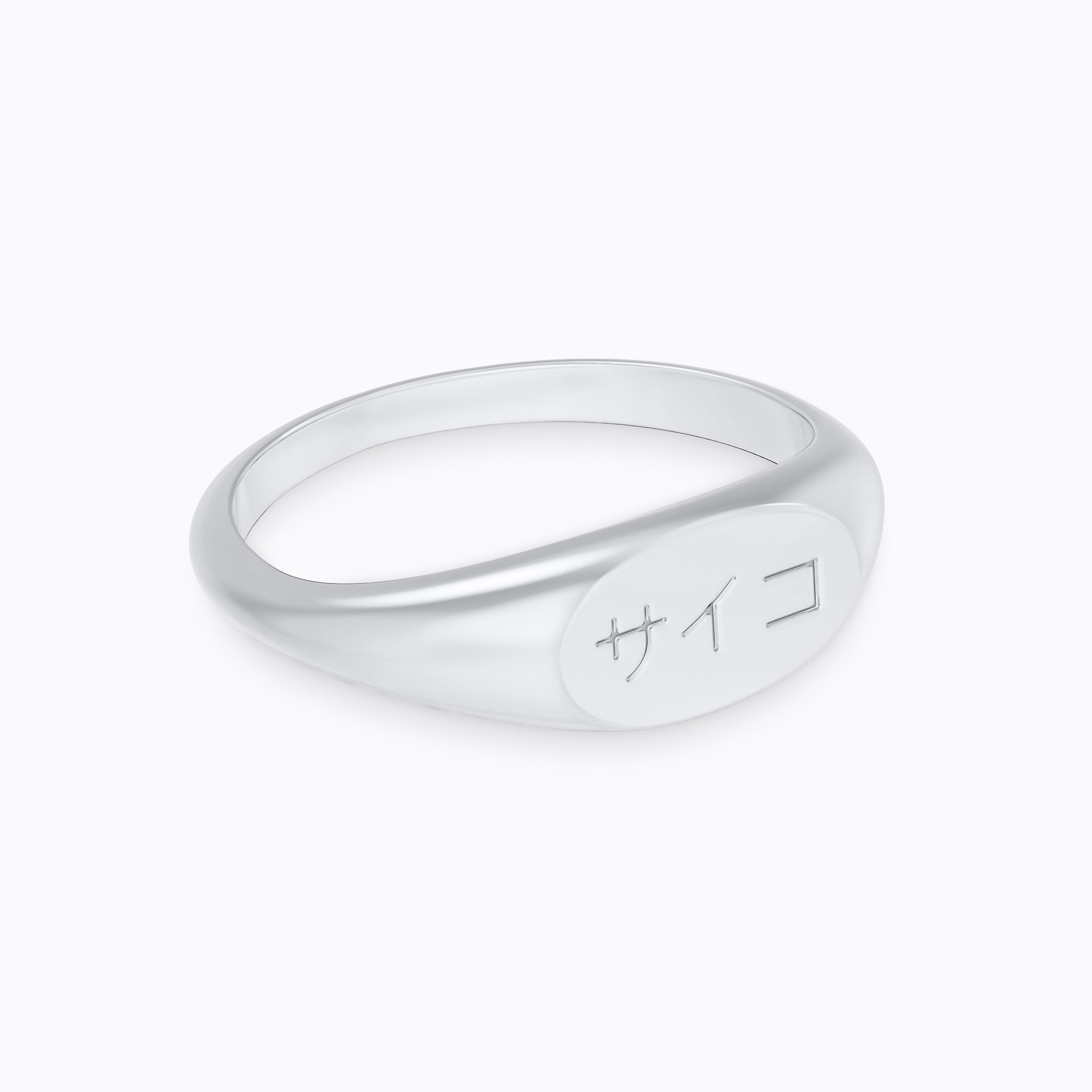 Silver stainless steel 316L signet ring with Japanese SAIKO logo engraved placed on the ground with a white background