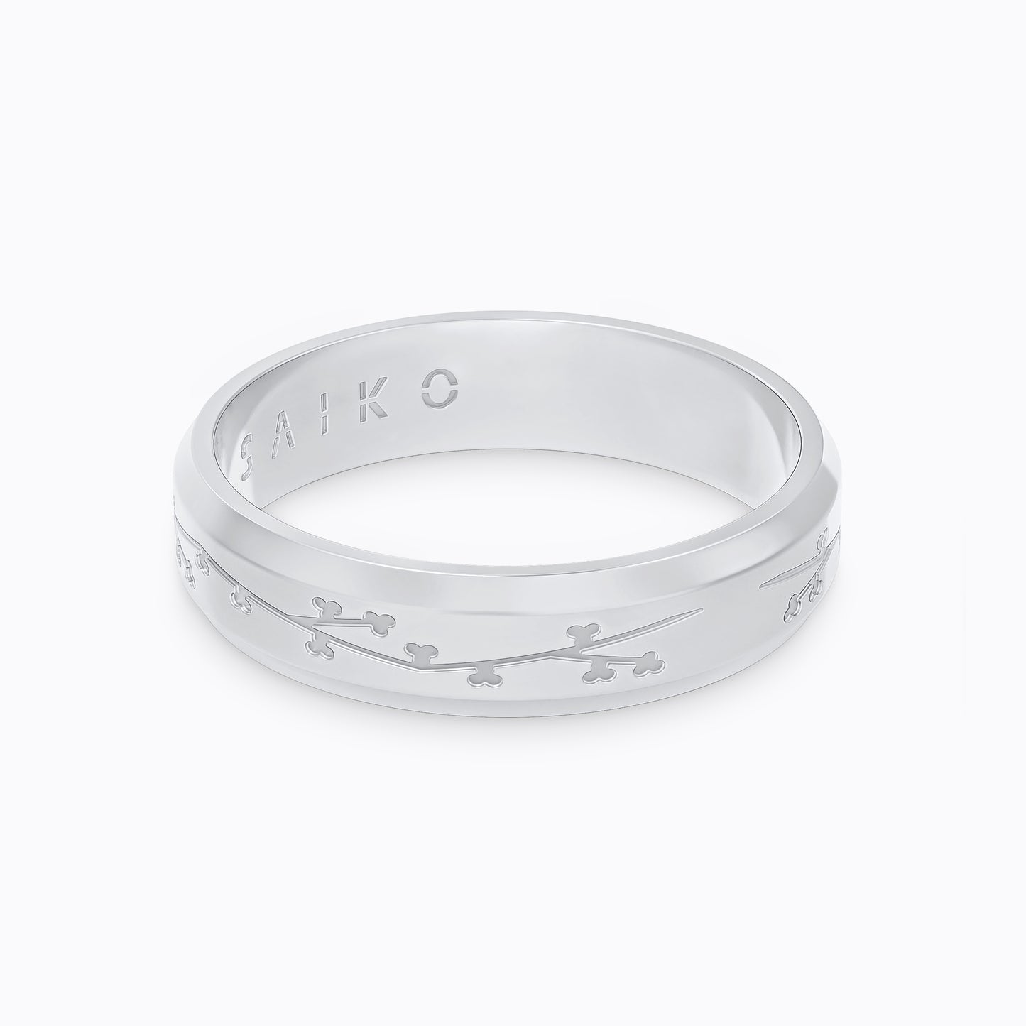 Silver stainless steel 316L ring with cherry blossom engraving placed on the ground with a white background