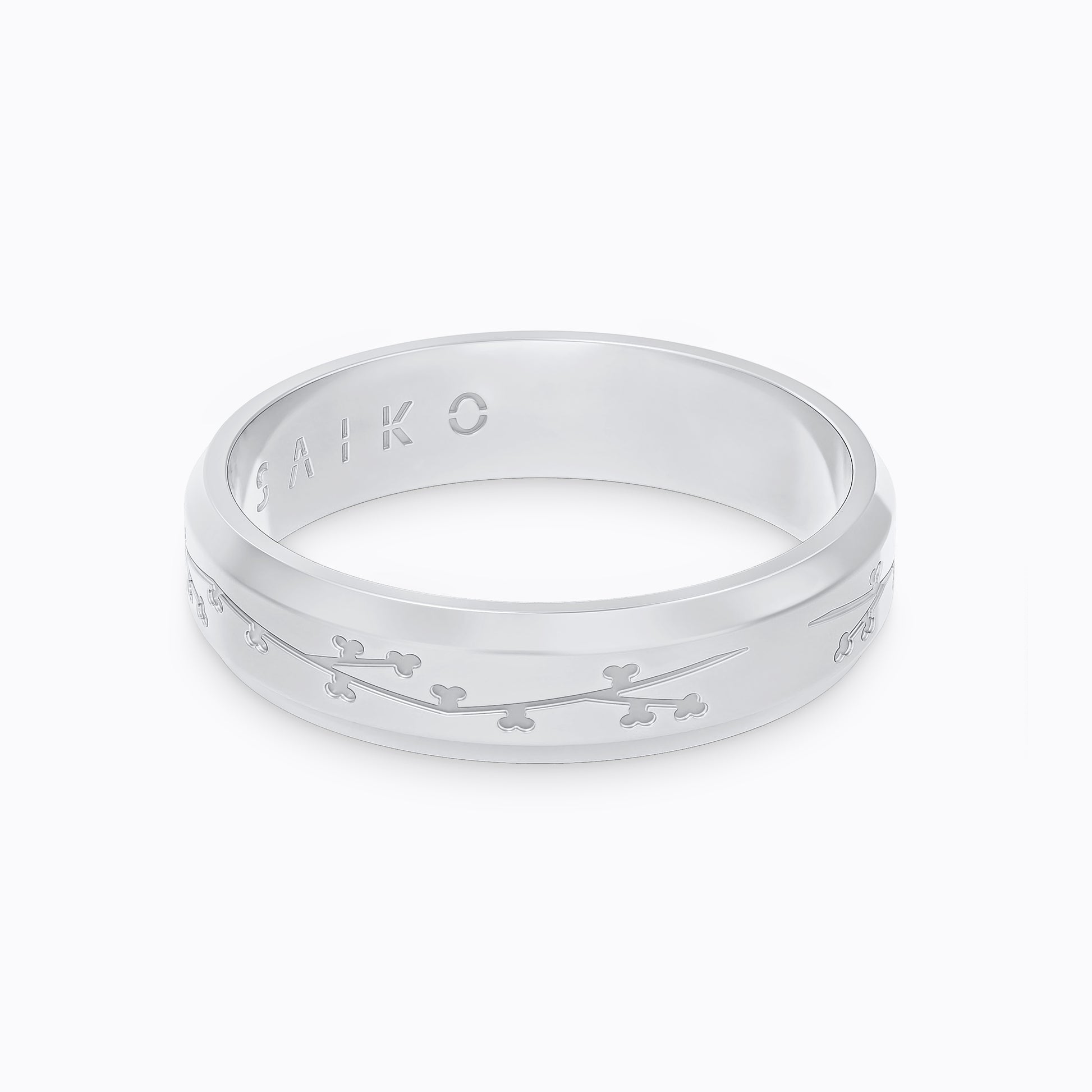 Silver stainless steel 316L ring with cherry blossom engraving placed on the ground with a white background