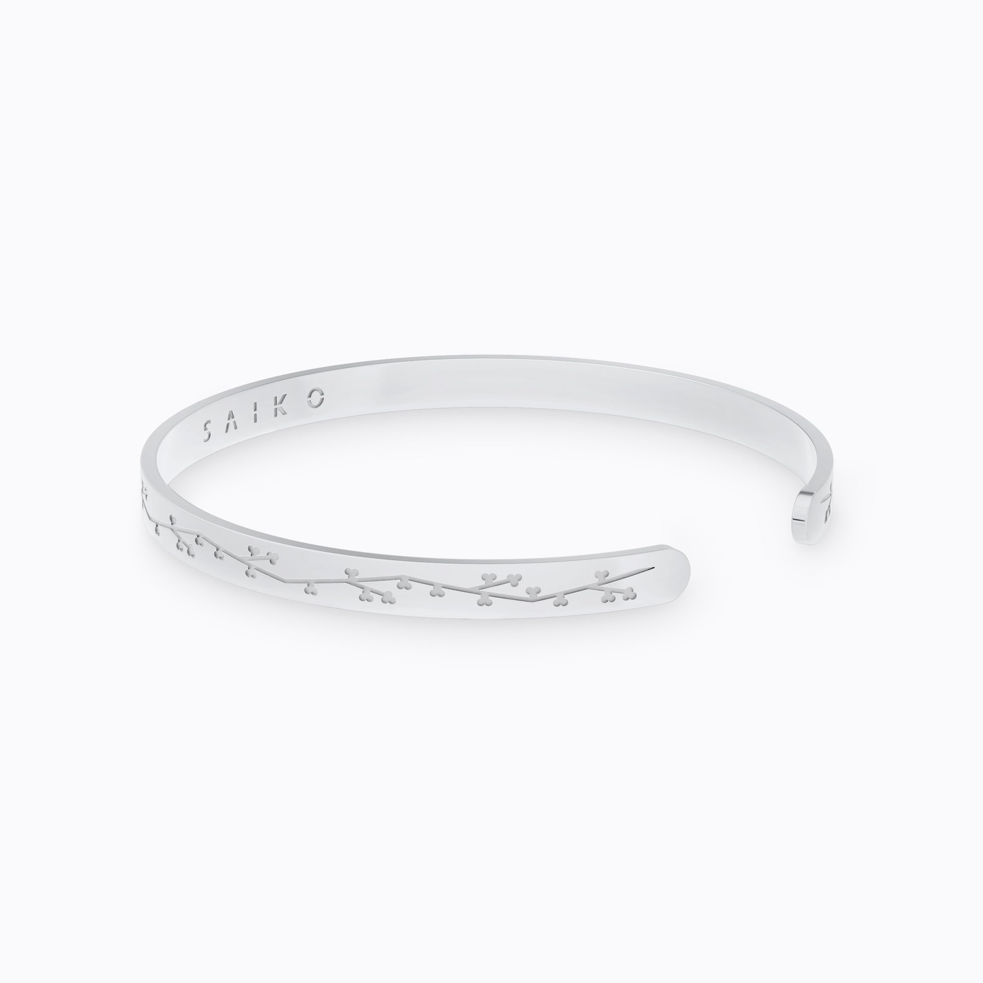 Silver stainless steel 316L cuff bracelet bangle with cherry blossom engraving placed on the ground with a white background