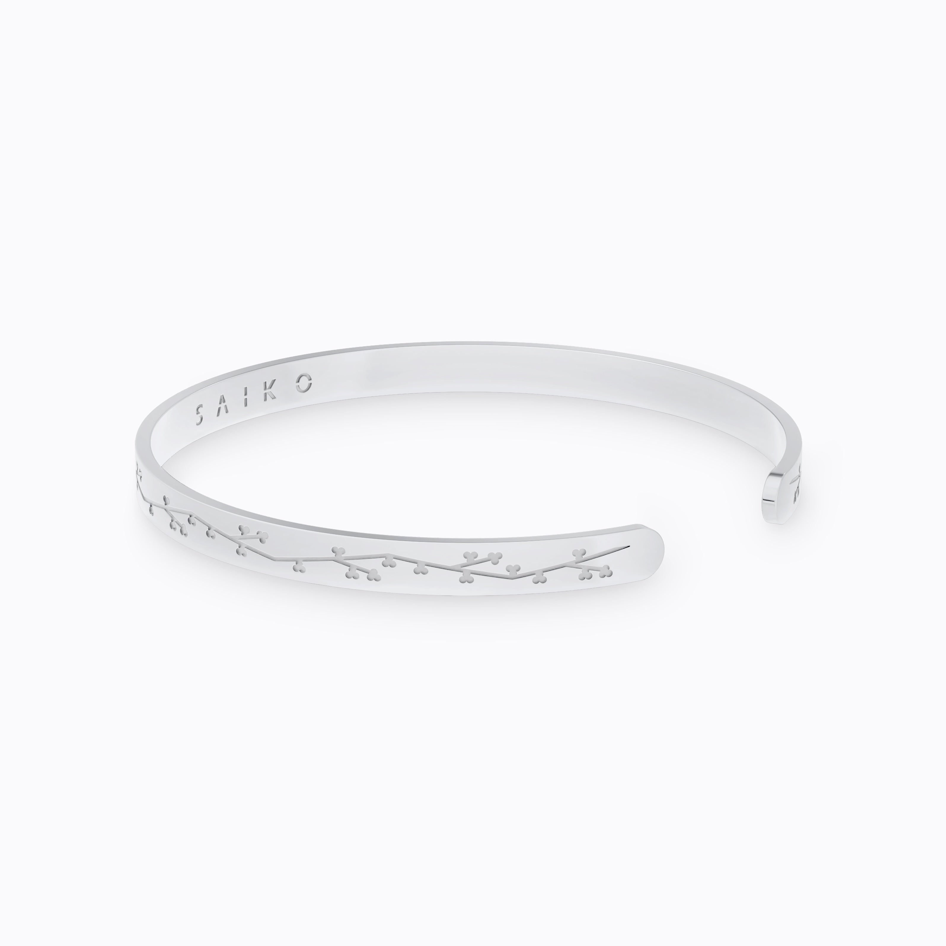 Silver stainless steel 316L cuff bracelet bangle with cherry blossom engraving placed on the ground with a white background